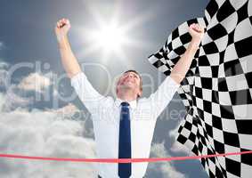 Business man at finish line against sky and checkered flag