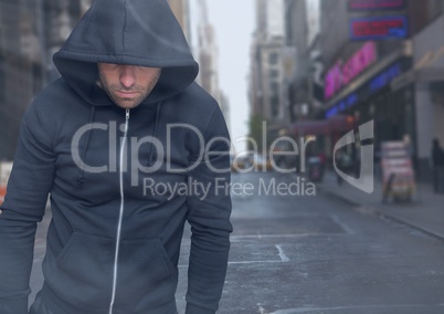 Criminal in hood in front of city street