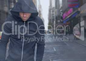 Criminal in hood in front of city street