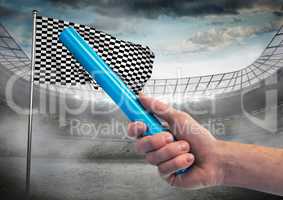 Hand with blue baton against stadium with flare and checkered flag