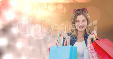 Portrait of woman with carrying shopping bags over bokeh