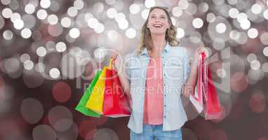 Woman with carrying shopping bags over bokeh
