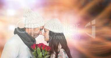 Loving couple with roses during winter over bokeh