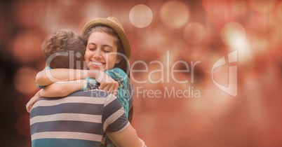 Happy woman embracing man over blur background
