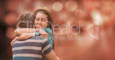 Happy woman embracing man over blur background