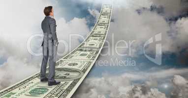Digital composite image of businessman standing on money walkway in sky