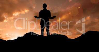 Silhouette businessman standing on mountain during sunset