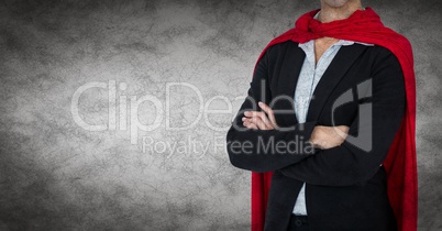 Business woman superhero mid section with arms folded against grey background and grunge overlay