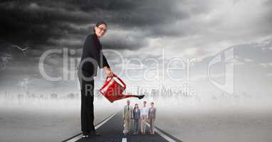 Digital composite image of businesswoman watering employees on street