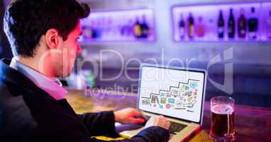 Businessman using laptop while sitting in bar