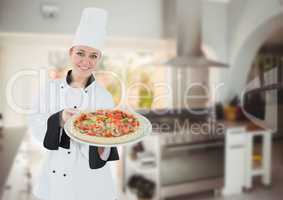 Happy chef showing the pizza in the kitchen