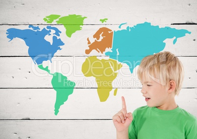 Boy pointing at Colorful Map with paint splatters on wood background