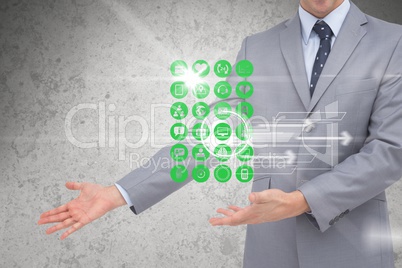 Digital composite image of various icons with businessman gesturing in background