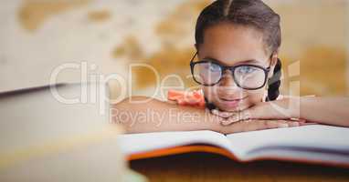 Girl at desk with books against blurry brown map