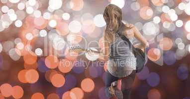 Rear view of music artist playing guitar over bokeh