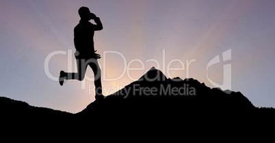 Silhouette businessman using phone while running on mountain against sky