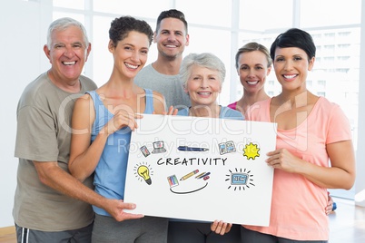 Portrait of family holding billboard with cretivity text and various icosn while standing at home