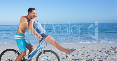 Carefree couple riding cycle at beach