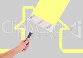 hand with roller painting the yellow house background
