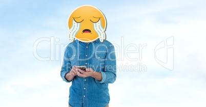 Person with crying emoji over face using smart phone