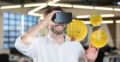 Man trying to touch emojis while wearing VR glasses