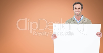 Portrait of man holding blank billboard against orange background