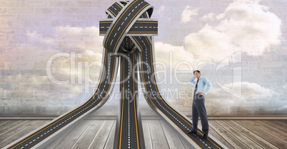 Confused businessman standing on tangled highway