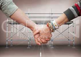 Close up of couple holding hands and flare against scaffolding in grey