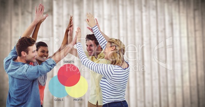Team highfiving against colourful ven diagram and blurry wood panel
