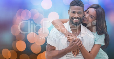 Loving woman embracing man over bokeh