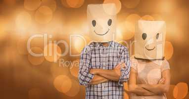 Couple covering faces with paper bag with smileys drawn on it