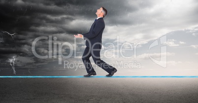 Digital composite image of businessman walking on rope during thunder storm
