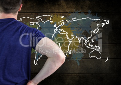 Man in T-Shirt looking at Colorful Map with paint splatters on wall background