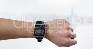 Hand with watch against blurry white skyline