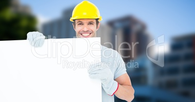 Happy worker wearing hardhat while holding blank bill board