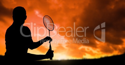 Silhouette man playing badminton against cloudy sky during sunset