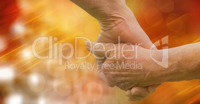 Close-up of senior couple holding hands over blur background