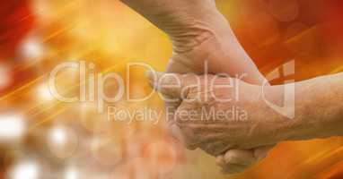 Close-up of senior couple holding hands over blur background