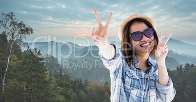 Happy woman showing victory sign while traveling on mountains