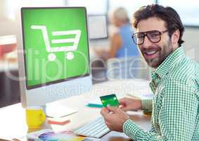 Man using computer with Shopping trolley icon