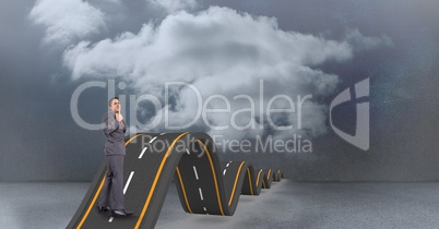 Digital composite image of businessman standing on wavy road in sky