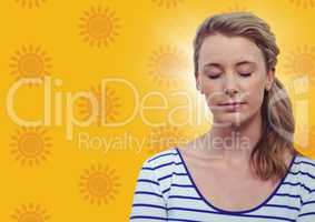 Woman with eyes closed against yellow sun pattern