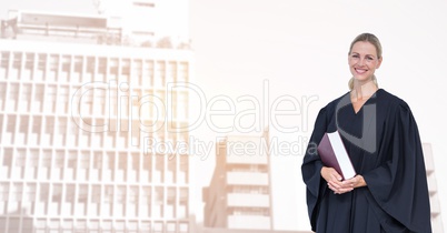 Portrait of smiling judge holding book in city