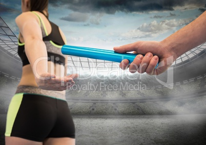 Hand with blue baton against stadium with flares