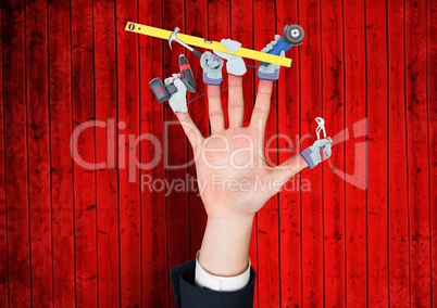 Hand with hands with tools on the fingers. Red wood background