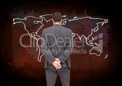 Businessman looking at Colorful Map with paint splatters on wall background