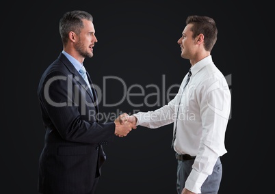 Business man shaking hands against dark grey background