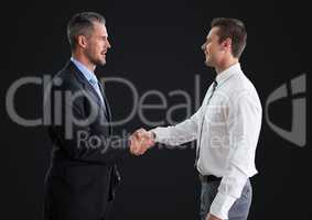 Business man shaking hands against dark grey background