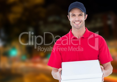 Happy deliveryman with the boxes of the pizza in the city at night. Lights