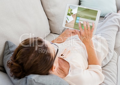 Woman on the sofa with tablet. Login on the screen